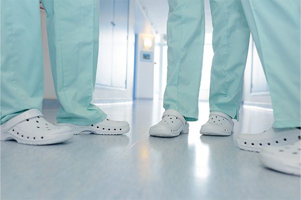 Gesundheitspersonal in weissen Schuhen, im Gang eines Krankenhauses