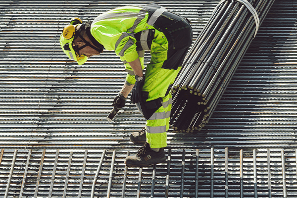 Stahlkappenschuhe schützen den Arbeiter vor Verletzungen seiner Zehen, während er auf Metallgerüsten arbeitet.